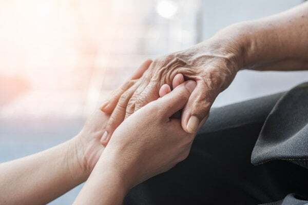 memory-care-young-caregiver-holding-elderly-hands-2