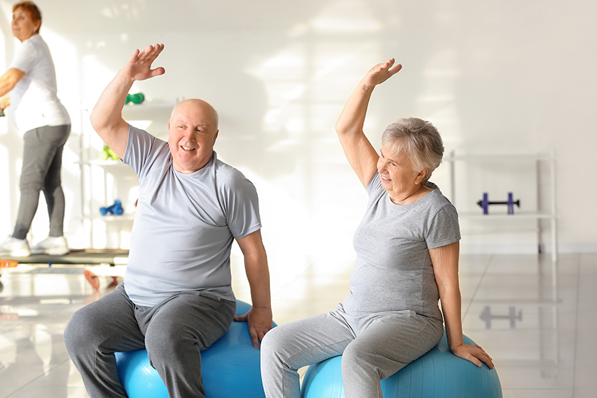 elderly man woman exercising gym