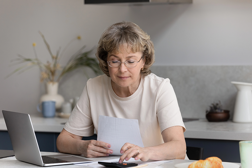 focused middle aged woman calculating bills