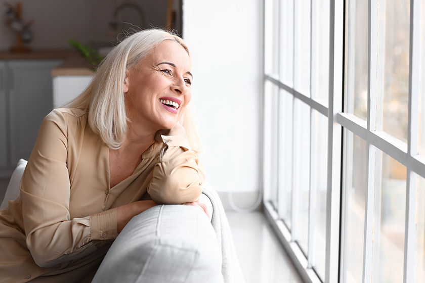 Morning of beautiful mature woman sitting on sofa