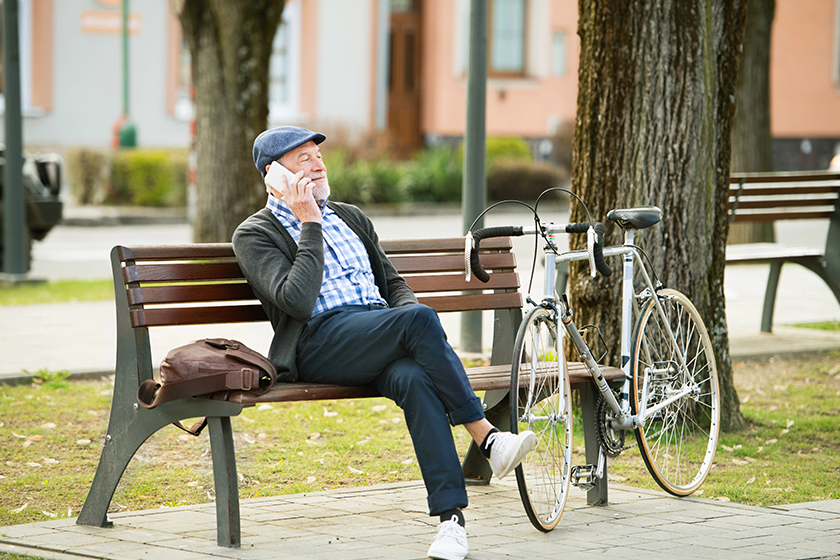 senior man with bicycle and smart phone